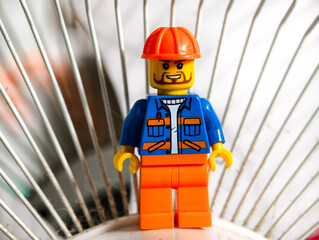 Fototapeta premium Russia, St. Petersburg, August 8, 2020 A close-up shot of a Lego man wearing a hard hat, ideal for use in illustrations or designs requiring a small, detailed figure