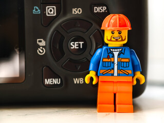 Fototapeta premium Russia, St. Petersburg, August 8, 2020 A lego man standing next to a camera, great for illustration or design concept