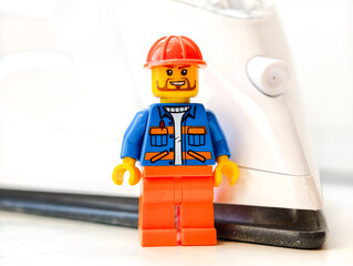 Fototapeta premium Russia, St. Petersburg, August 8, 2020 A lego man standing next to an iron, great for illustration of creativity and technology