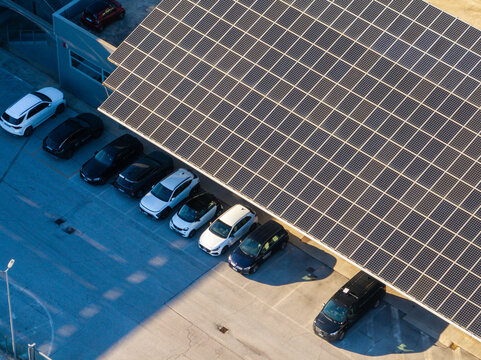Aerial view of a parking lot covered by solar panels with rows of parked cars in Ancona, Marche, Italy.