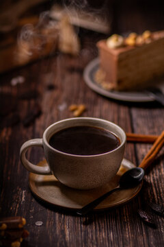 Eine Tasse Kaffee mit Kuchen auf rustikalem Holztisch