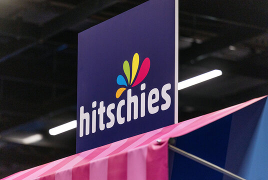 Cologne, Germany - August 26, 2026: Colorful hitschies logo displayed prominently at a gaming trade fair booth with vibrant branding elements and a modern design aesthetic