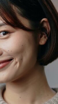 Vertical video: Raising right hand, woman tucking hair behind ear at studio meeting gaze