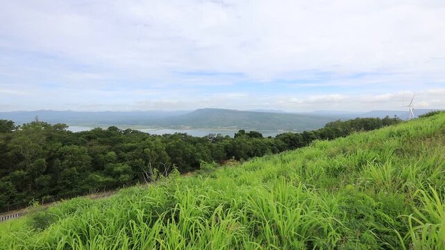 A scenic video view from the high-altitude wind turbine viewpoint at Khao Yai Thiang, Korat, Thailand, featuring beautiful scenery that overlooks the Lam Takhong Dam and wind energy infrastructure.