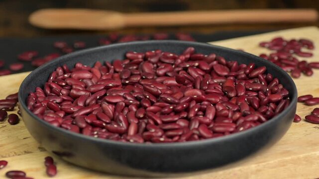 Raw red beans falling on a plate, slow motion 