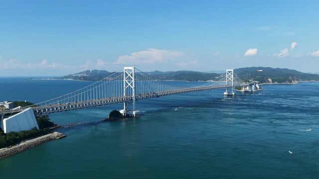 Aerial drone footage of Naruto Strait and suspension bridge in Naruto, Tokushima, Japan