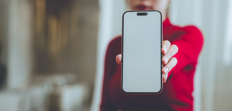 A person holding a blank smartphone and takeaway coffee, representing mobile communication, modern lifestyle, digital technology, and everyday convenience.