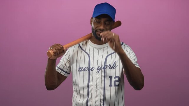 Man holding baseball bat on shoulder in studio wearing pinstripe jersey and blue cap, number 12 visible, relaxed pose and slight smile; confidence teamwork.