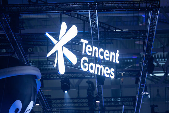 Cologne, Germany - August 26, 2026: Tencent Games illuminated sign displayed prominently at a gaming trade fair with overhead lighting and structural framework visible