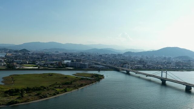 Aerial drone footage over Yoshino River and cityscape in Tokushima, Japan