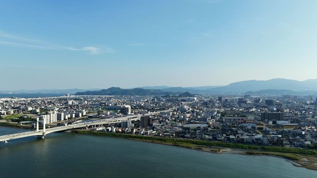 Aerial drone footage over Yoshino River and urban area in Tokushima, Japan