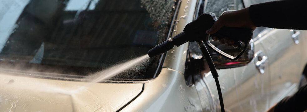 Car cleaning with pressure washer, hand washing vehicle with high pressure water spray for car wash and auto care, removing dirt from automotive surface during vehicle cleaning-banner