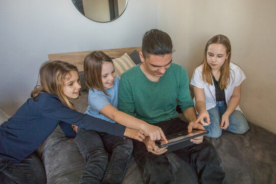 Group of children enjoying a game together while sitting on a bed in a cozy room in the afternoon