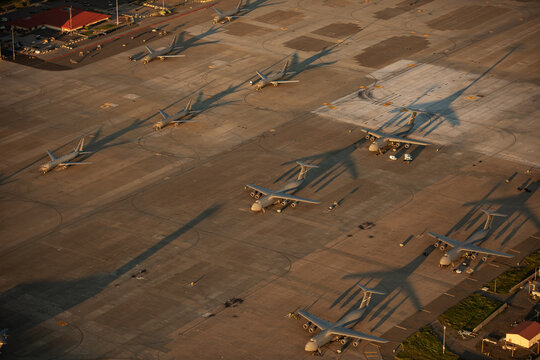 Aerial view of military transport aircraft parked on the tarmac at Travis Air Force Base during golden hour in Fairfield, California, United States.