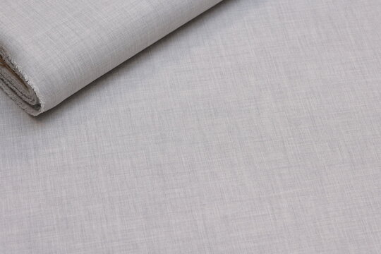 Premium light gray Italian suiting fabric featuring a subtle melange weave. This sophisticated, elegant textile combines a smooth surface with a refined pattern, perfect for tailored business apparel.