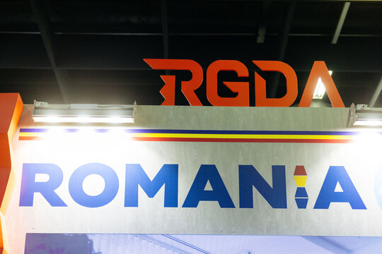Cologne, Germany - August 26, 2026: RGDA logo displayed prominently above the word Romania on a trade fair booth at an international gaming event showcasing national representation