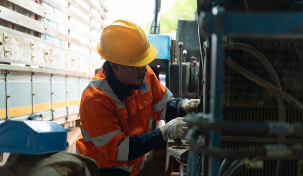 Tractor mechanic inspecting and repairing engine components while performing agricultural machinery maintenance, ensuring reliable equipment operation and efficient farming performance.