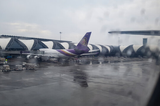 Bangkok, Thailand - April 07, 2018 - Thai Airways Boeing 747 connected to jetway at Suvarnabhumi Airport Bangkok terminal on a rainy overcast day