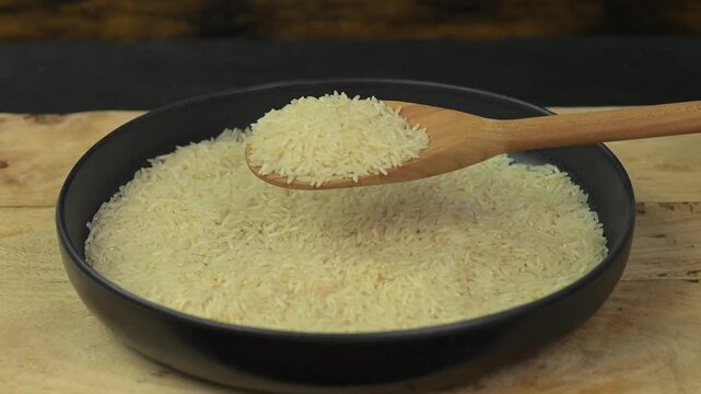 Adding white rice on a plate with a wooden spoon