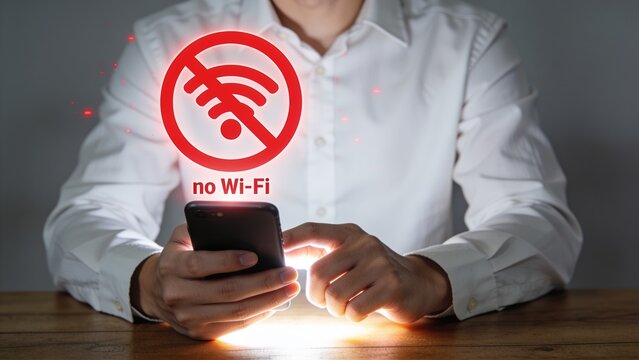 Man using smartphone with no Wi-Fi signal icon floating above