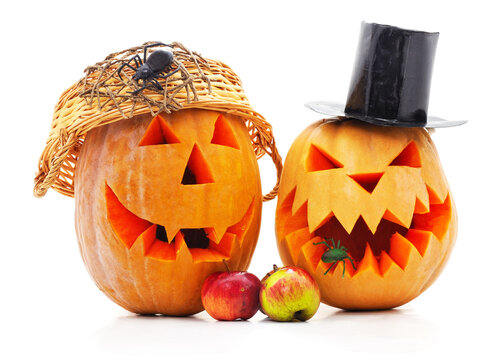 Two Halloween carved pumpkins wearing hats isolated on a white background.