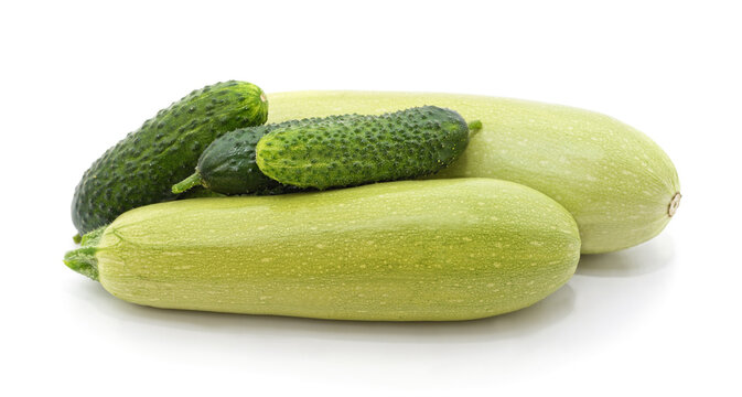Fresh green cucumbers and light green squashes isolated on a white background.