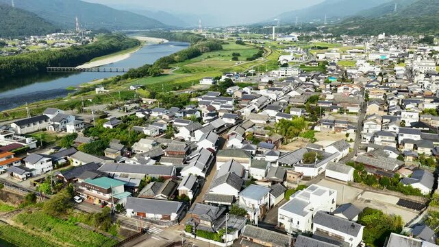 Aerial drone footage over residential town and Yoshino River in Mima, Tokushima, Japan