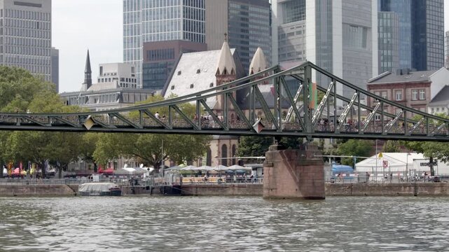 Pedestrians walk across the Eiserner Steg footbridge in downtown Frankfurt, Germany.