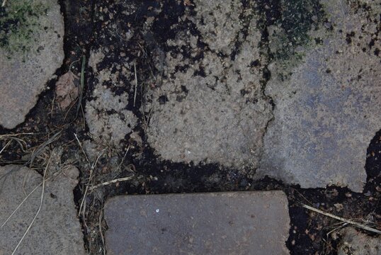 Concrete and red brick rubble texture background, old rough cement stone surface covered with green moss and stones, grunge industrial demolition backdrop.