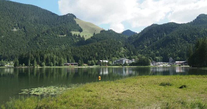 The magnificent resort of Spitzingsee at the foot of the alpine pastures and the Wilde Fraulein massif, seen from the verdant peninsula on the eastern shore
