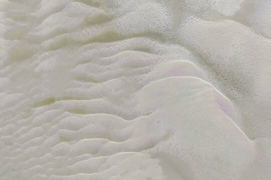 Aerial view of sand ripples forming intricate patterns on a beach in Australia.