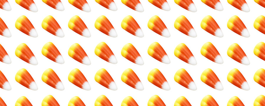 Repeating seamless pattern of candy corn pieces on transparent background	