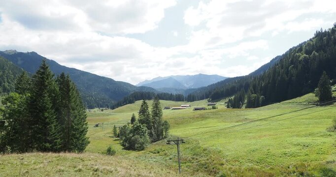 Around Lake Spitzingsee. Verdant meadows between the Rosskopf and Valepp trails. Ski area in winter. Hinteres Sonnwendjoch mountain range on the horizon