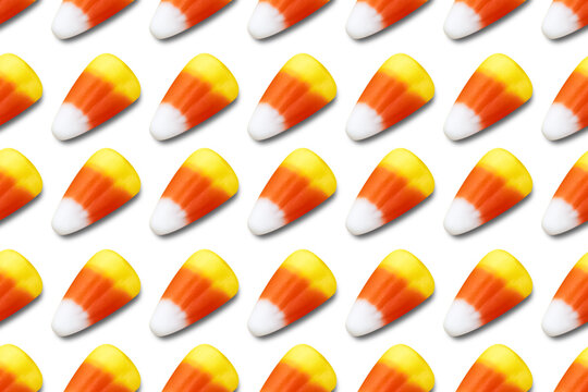 Repeating seamless pattern of candy corn pieces on transparent background	