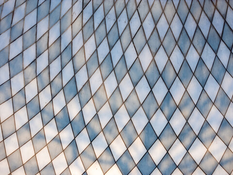 Aerial view of a modern glass facade with a diamond pattern reflecting the blue sky in Boyolali, Central Java, Indonesia.