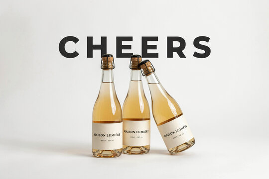 Cheers typography with champagne bottles, elegant sparkling wine bottles on white background, luxury rose wine celebration concept