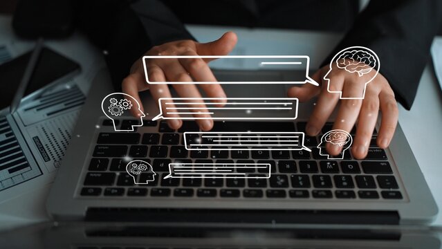 Business professional typing on laptop with digital communication icons, representing virtual interaction and collaboration in modern workplaces. Entropy.