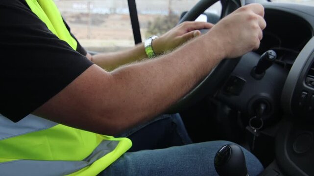 A delivery driver wearing PPE starting the van
