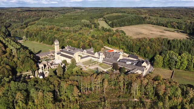 Aerial view of Orval Abbey nestled in the lush green forests during the daytime