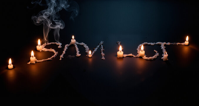 Candles illuminate a trail of smoke that seems to spell out a silent message, leaving a patch of dark background for your own. Moody & Mysterious

