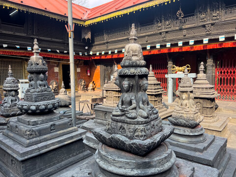 Ancient stone chaityas and carved Buddha shrines in the inner courtyard of Bijeshwari Temple in Kathmandu, Nepal