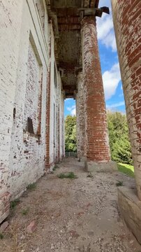 POV shooting, walking through columns and ruins of an old brick building.
