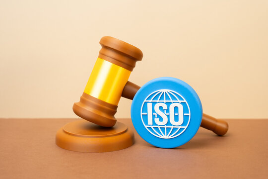 An ISO symbol and a judge's gavel. Legislation and standards. Concept of quality regulation and legal compliance. Certification and law enforcement. Global standards.