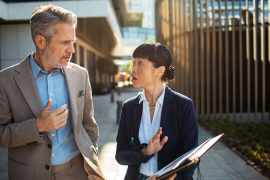 Business colleagues discussing project outdoors in city
