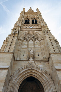 Neo-Gothic tower and ornate stone facade of Saint-Jean-Baptiste Church in Libourne, Nouvelle-Aquitaine, France