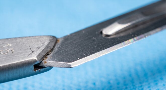 Surgical blade rests securely inside a metal handle during a procedure.