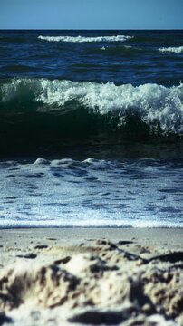 Ocean waves breaking sandy beach sea foam. Dynamic coastal scene capturing rolling tides and natural water movement along shoreline visual asset for travel tourism and environmental branding