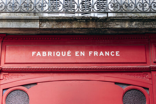 Bordeaux, France - July 14, 2026: Detail of the red facade of the Kidur clothing store with French inscriptions &ldquo;Manufacture de vetements&rdquo; and &ldquo;Fabrique en France&rdquo;