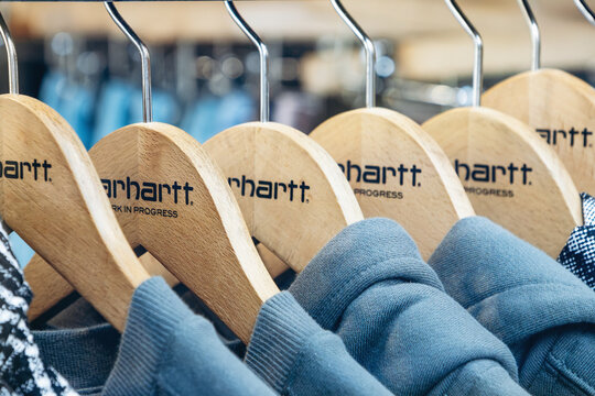 Bordeaux, France - July 14, 2026: Close-up of Carhartt Work In Progress branded wooden clothes hangers and apparel inside a Carhartt boutique in central Bordeaux