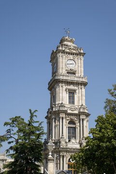 View of the ornate Dolmabahce Clock Tower with intricate stone carvings and arched windows set against a clear blue sky in Istanbul, Istanbul, Turkiye.